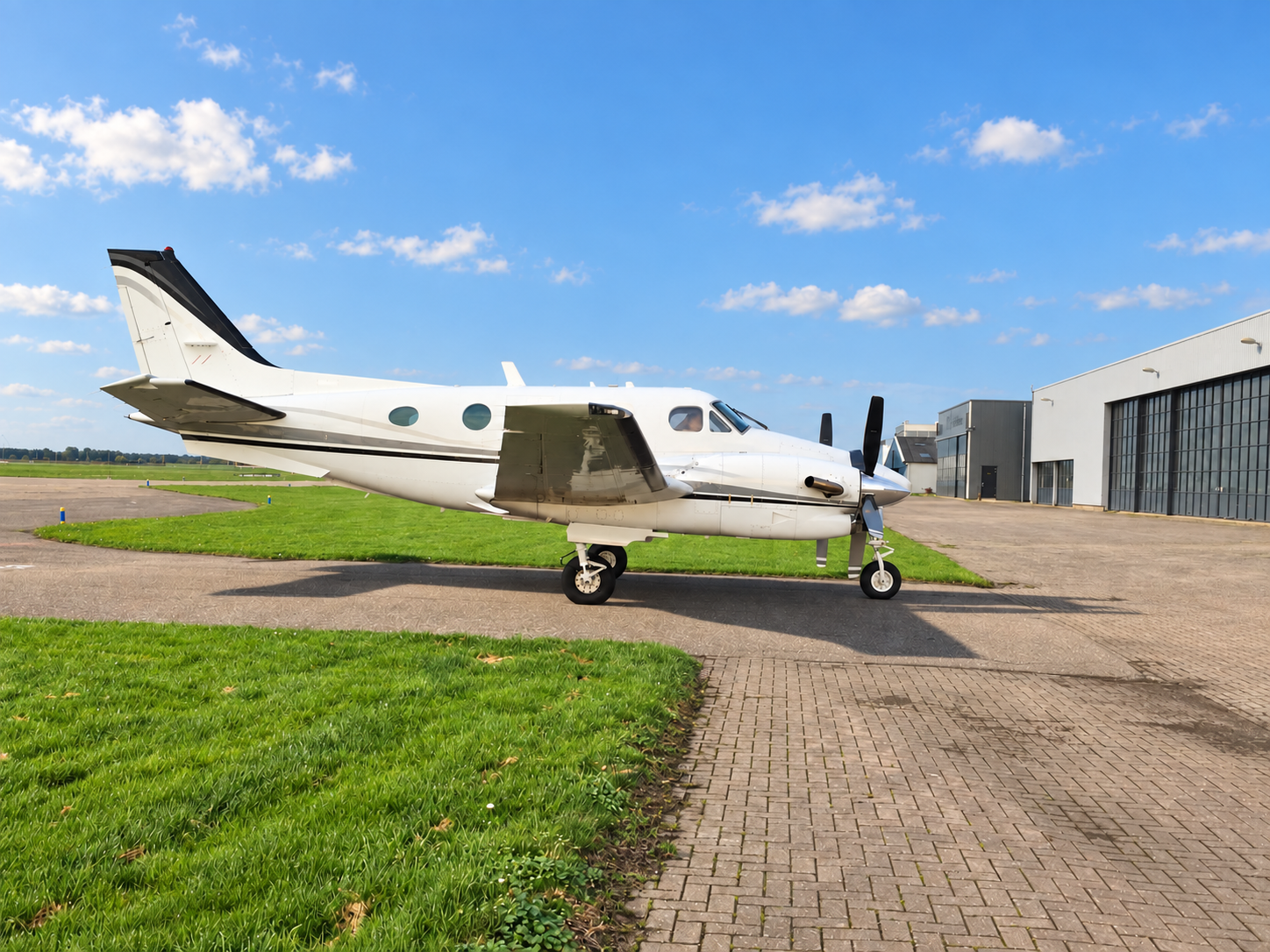 Beechcraft King Air C90 with a survey modification parked in front of a hangar