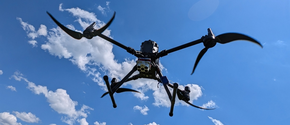 Survey multirotor in flight, sensor payload mounted underneath